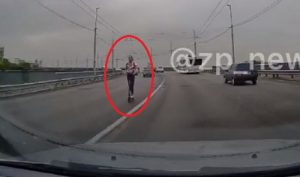 Среди десятков авто на плотине ДнепроГЭС ехала женщина на самокате (ВИДЕО)